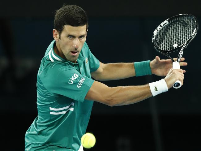 MELBOURNE, AUSTRALIA - FEBRUARY 08: Novak Djokovic of Serbia plays a backhand in his Men's Singles first round match against Jeremy Chardy of France during day one of the 2021 Australian Open at Melbourne Park on February 08, 2021 in Melbourne, Australia. (Photo by Darrian Traynor/Getty Images)