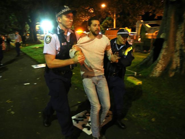 James Mathison gets taken away by police after climbing one of the trees being cut down in Sydney. Picture: Dylan Robinson