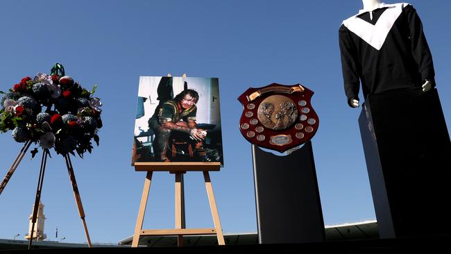 A wreath of flowers, a photo of Tommy Raudonikis playing for Australia, the State of Origin trophy and a Wests jersey is on display during the Tommy Raudonikis memorial service. Picture: Mark Kolbe/Getty Images