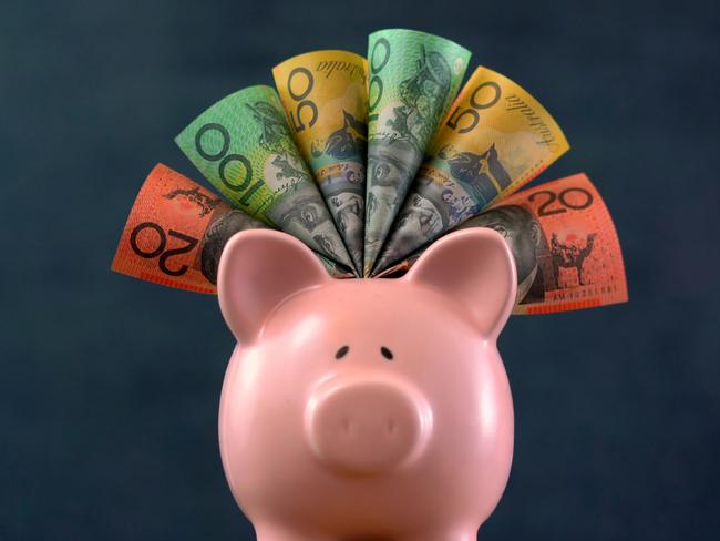 Pink Piggy bank money concept on dark blue background, stuffed with Australian cash.Federal Budget topic plan (May 8), onto the Piggybank pic topic