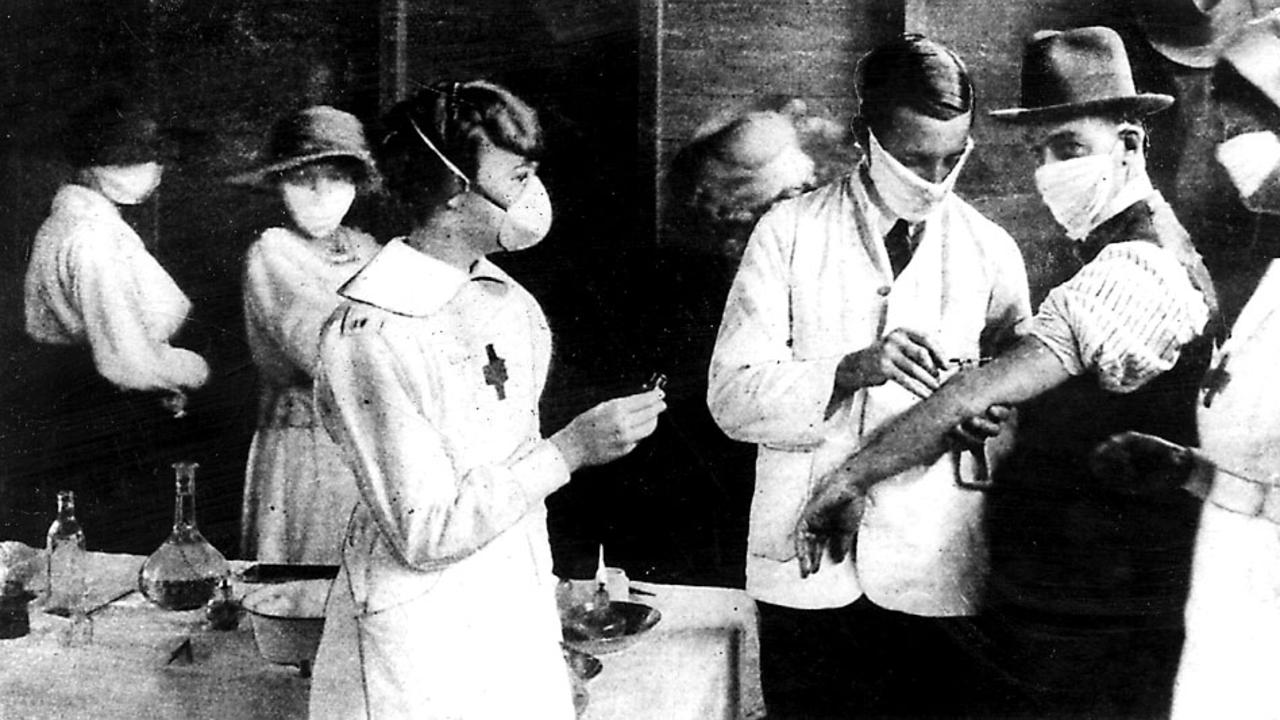 Medical staff wear protective masks while vaccinating patients at the Hyde Park inoculation depot during the Spanish flu epidemic.