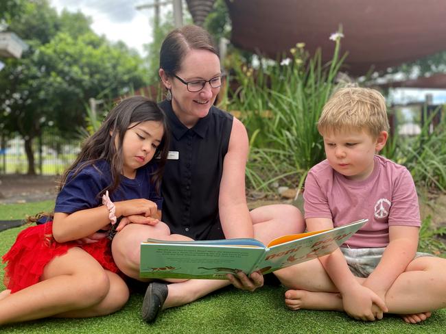 Ballina Fox Street Preschool director Lea May reads to Isla and Asher, aged 4. Picture: Contributed