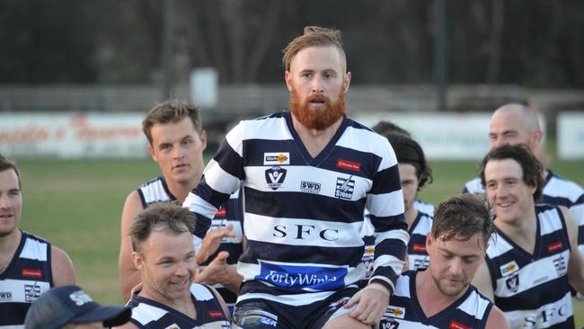 Lachlan Sharp is carried off by his teammates after his 150th game milestone.