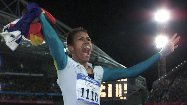 Athlete Cathy Freeman holds the Aboriginal and Australian flags after winning 400m final race at the Sydney Olympic Games in 2000.