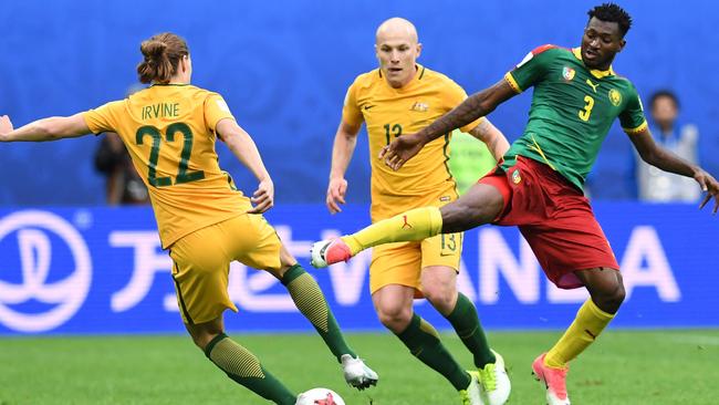 Australia's midfielder Jackson Irvine vies for the ball against Cameroon's midfielder Andre Zambo.