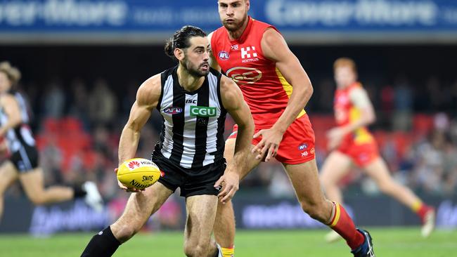 Brodie Grundy of the Magpies chased by Jarrod Witts of the Suns. Picture: AAP Image