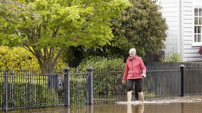 Julie Lunson walks through flood waters from her home in Latrobe. Picture: Grant Viney