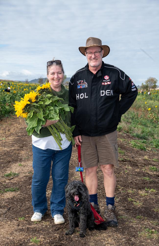 Ro Brinkman and Jason Vidulich, with their dog Champ, enjoy the walk through the fields.Open day at Warraba Sunflowers, Cambooya. Saturday June 29th, 2024
