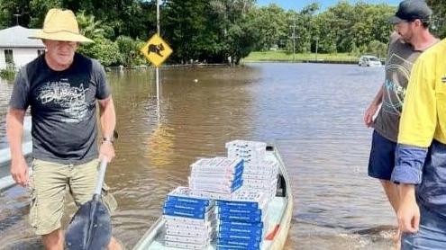 Locals using a canoe to transport their pizzas from Domino’s Alstonville during the 2022 floods. Picture: Facebook.