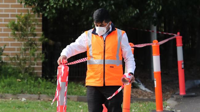 A security officer tapes up the entrance to Anglicare's Newmarch House at Caddens in western Sydney, which recorded COVID-19 related deaths. Picture: Richard Dobson