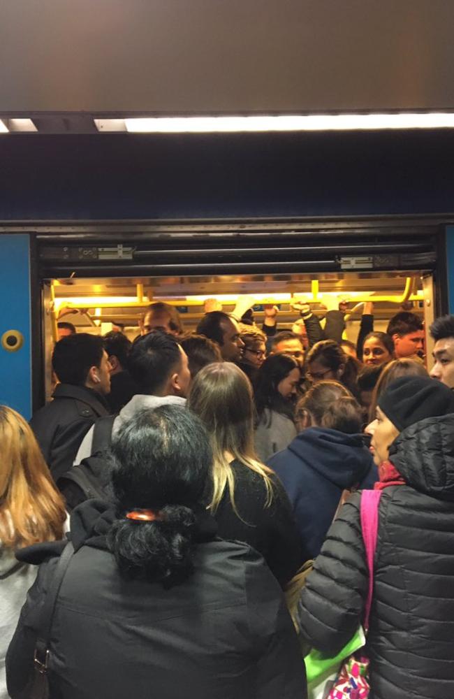 Commuters crush on to a train at Melbourne Central station. Picture: Kara Lambert