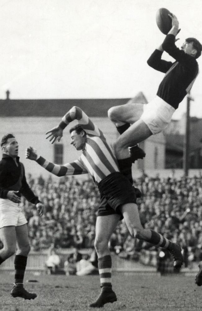 There has been little change to Essendon’s guernsey since the 1890s. Here, John Coleman takes a screamer over North Melbourne’s Vic Lawrence in June 1953. Picture: News Corp Australia