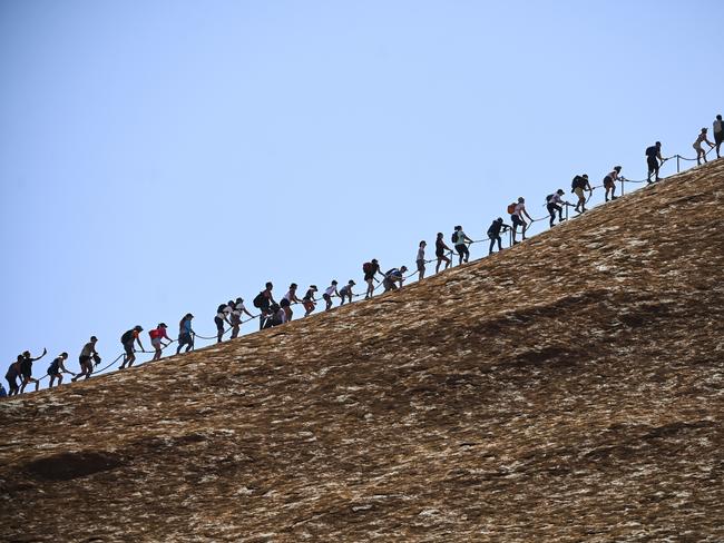 Tourists are seen climbing Uluru, also known as Ayers Rock at Uluru-Kata Tjuta National Park in the Northern Territory on the last day. Picture: AAP