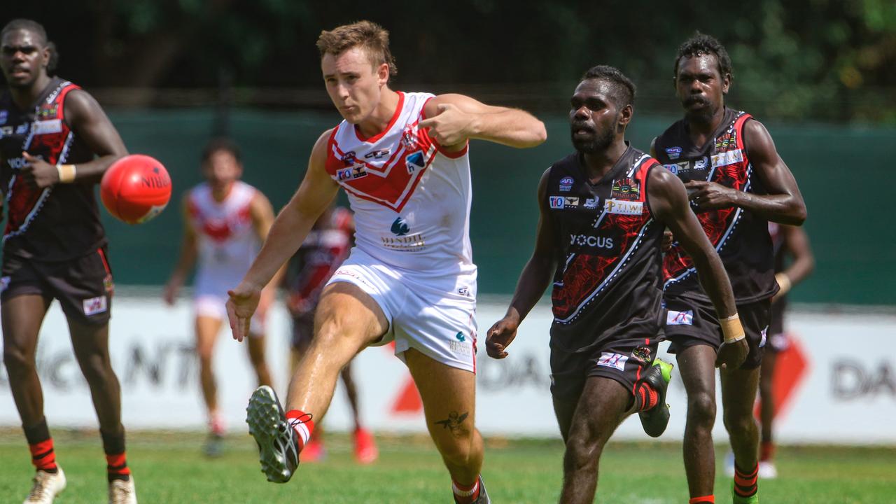 Geelong footballers chase a kick in Darwin