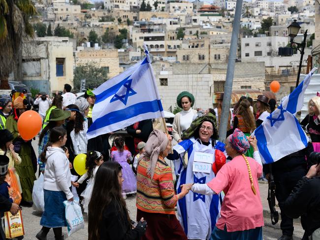 HEBRON, WEST BANK - MARCH 24: A member of Knesset (parliament) wearing an Israeli flag costume celebrate Purim as Israeli security forces secure the celebrations March 24, 2024 in Hebron, West Bank. Unlike previous years, this year due to the Israel- Hamas war, the parade and celebrations, were scaled back. The Jewish holiday of Purim commemorates the saving of the Jewish people in ancient Persia. The principal day of celebration is from sunset on March 23 to nightfall on March 24.  (Photo by Alexi J. Rosenfeld/Getty Images) *** BESTPIX ***