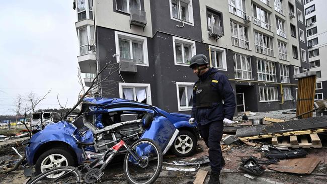 A field engineer of the State Emergency Service of Ukraine checks a damaged residential area in Bucha. Ukrainian officials say over 400 civilian bodies have been recovered from the wider Kyiv region, many of which were buried in mass graves.