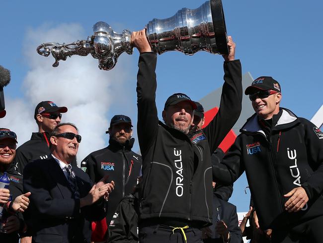 Larry Ellison hoists the America’s Cup trophy after the team he financed won the race.