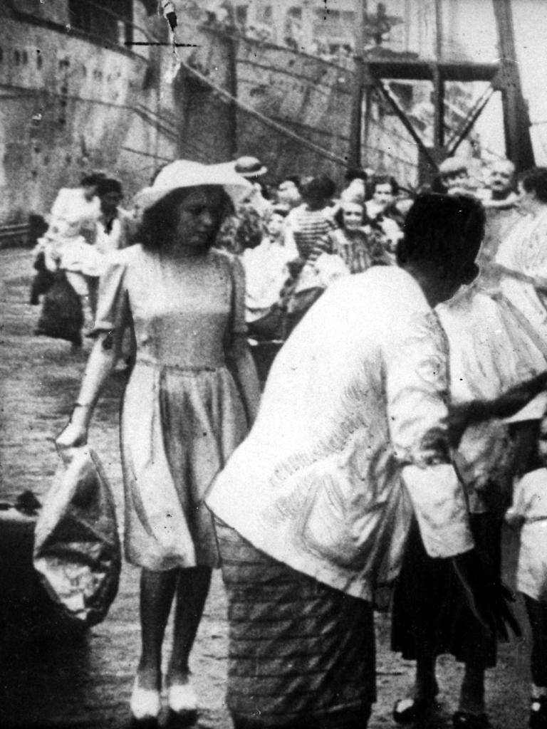 Refugees queue on a Singapore wharf to board a ship out, before the final desperate rush Vivian saw.