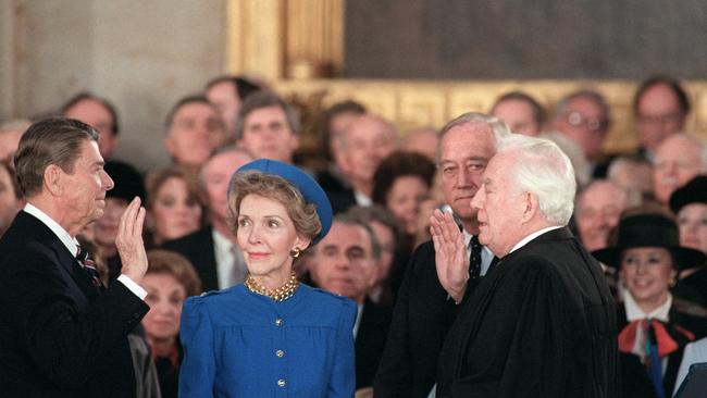 Ronald Reagan is sworn in for his second presidential term by Chief Justice Warren Burger beside his wife Nancy Reagan indoors in January 1985. Picture: CONSOLIDATED NEWS PICTURES / AFP