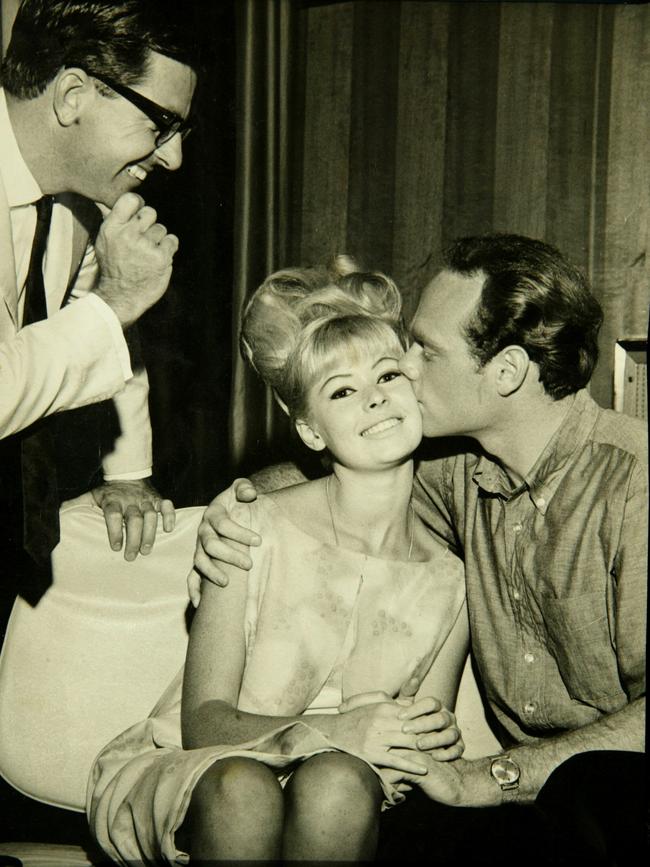 Sandra Love (Powell) is kissed by Mike Love as radio personality Bob Rogers looks on during the band’s tour of Australia in 1964.