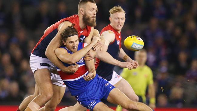 Marcus Bontempelli gets a handball away as he’s tackled by Max Gawn. Picture: Michael Klein