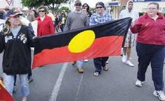 Pride on display: Marchers proudly carry the Aboriginal flag during yesterday’s NAIDOC Week mark in River Street, Ballina. . Picture: Doug Eaton