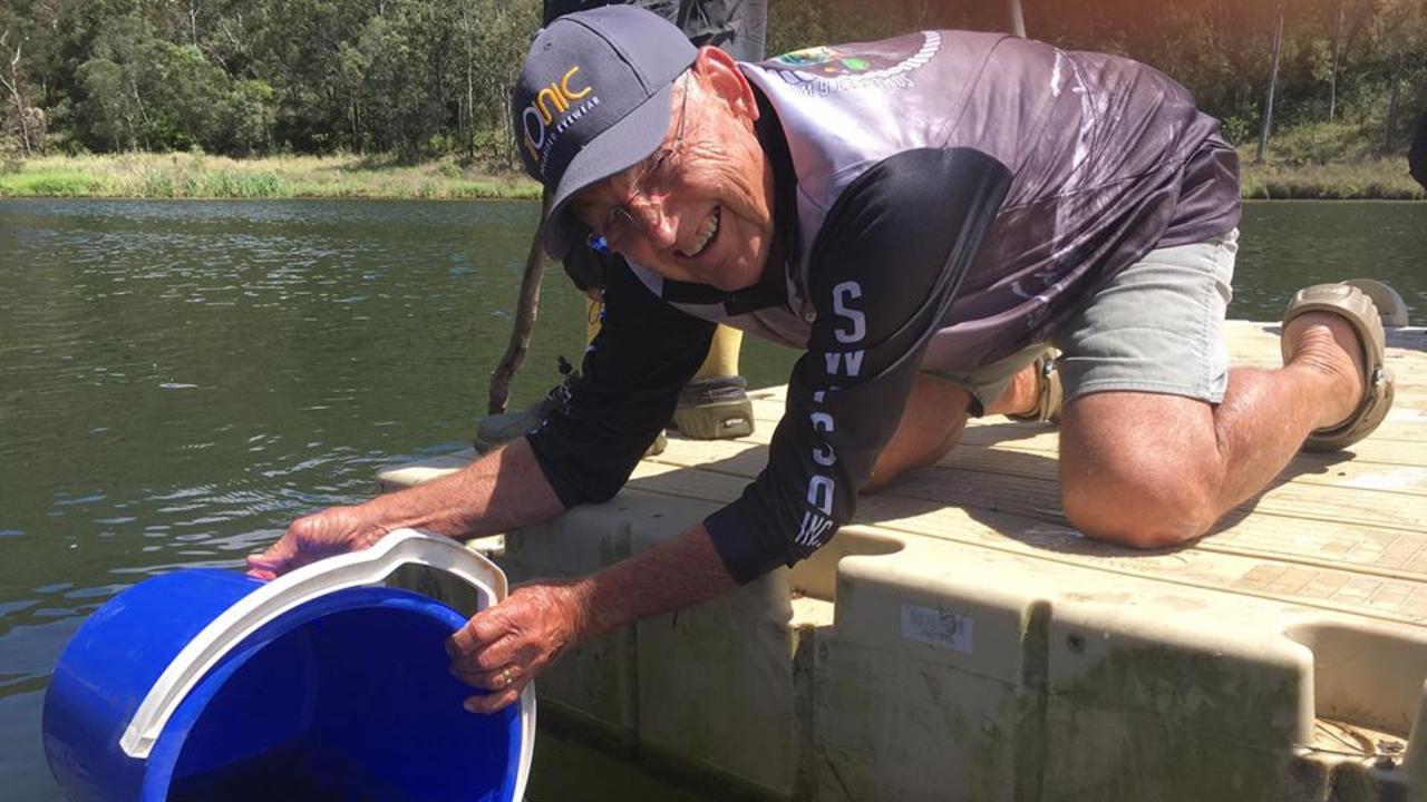 Somerset and Wivenhoe Fish Stocking Association life member Bunny Qualischefski releases a batch of fingerlings.