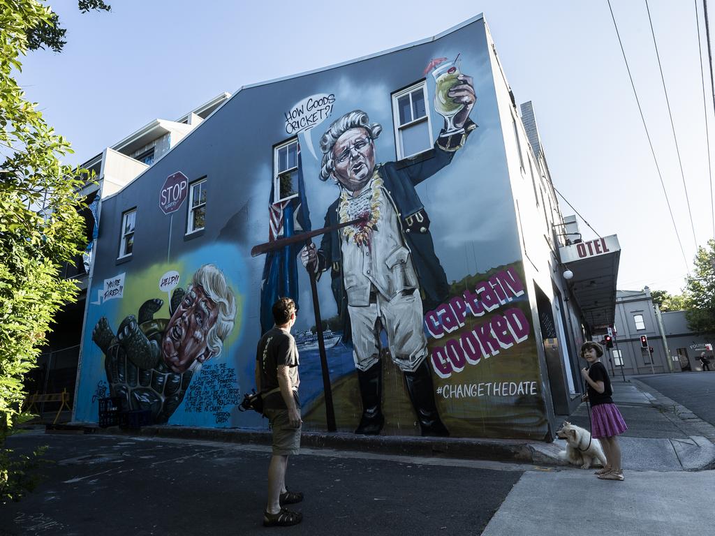 People look at a mural by street artist Scott Marsh in Newtown early on Australia Day. Picture: Brook Mitchell/Getty Images