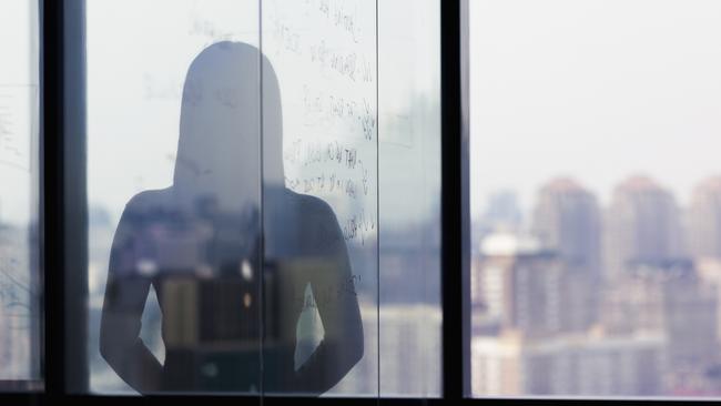 Silhouette shadow of woman looking at city from office