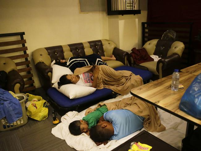 Guests sleep inside a hotel restaurant after the roof of their room was partly damaged due to strong winds from Typhoon Mangkut in Tuguegarao city, Cagayan province, northeastern Philippines on Saturday. Picture: Aaron Favila