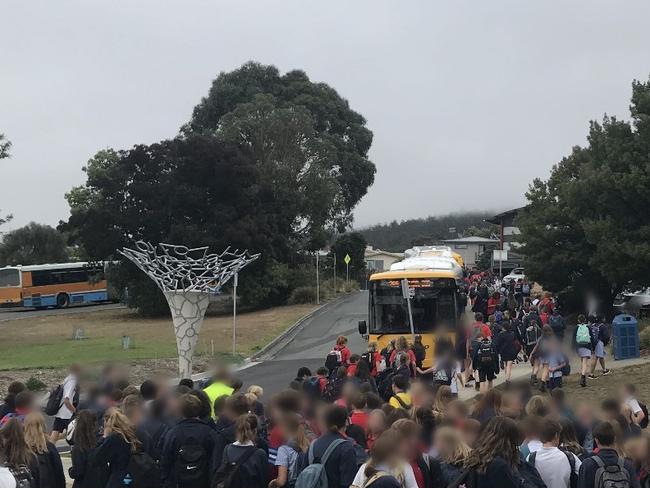 Crowds of Taroona High School students wait to board buses.