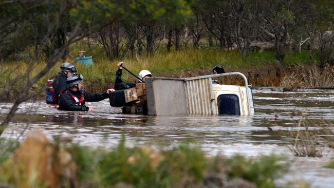 Police at the scene in Wallacedale where a local farmer’s ute was swept into a dam by floodwaters.