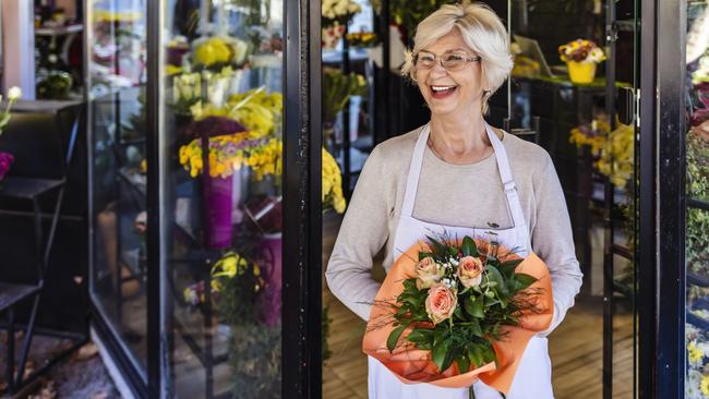 Senior Florist Small Business Flower Shop Owner standing while holding beautiful bouquet with roses; Senior employee generic