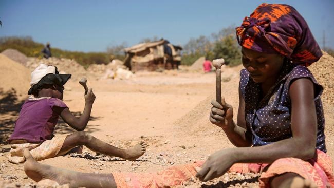 A child and a woman break rocks extracted from a cobalt mine in the Democratic Republic of Congo. Picture: AFP