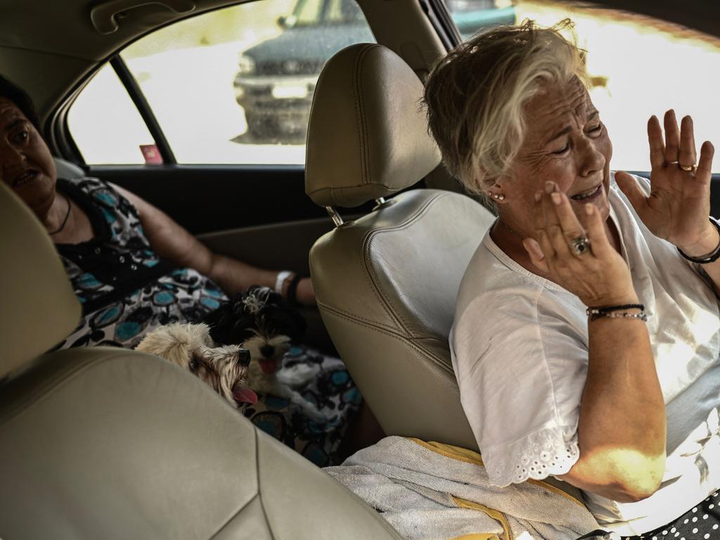 Local residents react as a wildfire spreads in Acharnes, north of Athens. Picture: Angelos Tzortzinis / AFP