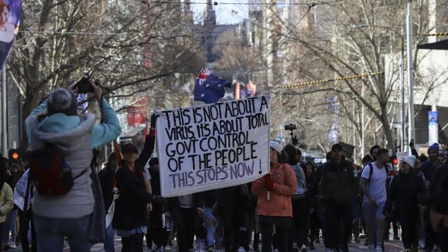 Protesters hold a banner while walking through Bourke Street during a rally for freedom in Melbourne. Picture: Getty