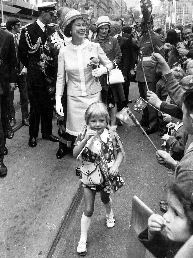 <b>1970 – Melbourne</b> The new informality of the 1970 tour is clear in this shot from Melbourne, which shows a young girl continuing to walk ahead of the Queen after scampering from the crowd to present a small bunch of flowers.