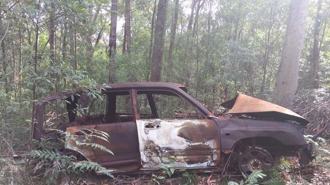 The burnt out getaway car hidden in bushland on the direction of Hamalainen. Picture: NSW POLICE