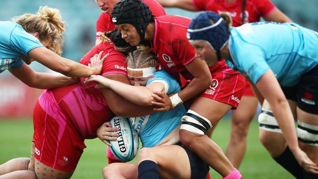 Emily Robinson of NSW is wrapped up by the Queensland defence in the Super W grand final on Friday.