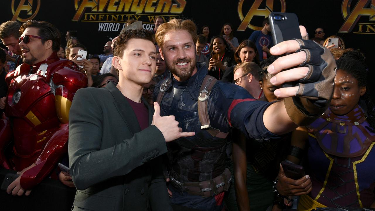 Tom Holland takes a selfie with a fan at the premiere of Avengers: Infinity War.