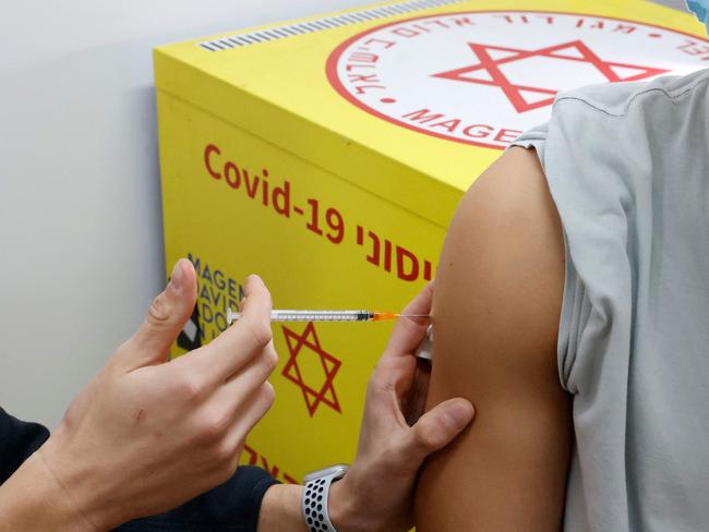 An Israeli medical personnel administers a dose of the Pfizer-BioNtech vaccine against the coronavirus to a young man, in the Israeli town of Ramat Gan near Tel Aviv. Picture: AFP