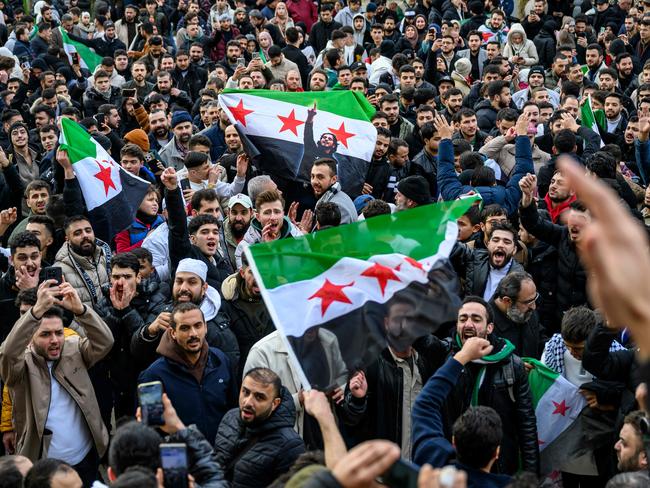 Syrians in Turkey wave Syrian flags as they celebrate the end of the Baath rule in Syria after rebel fighters took control of Damascus overnight. Picture: AFP