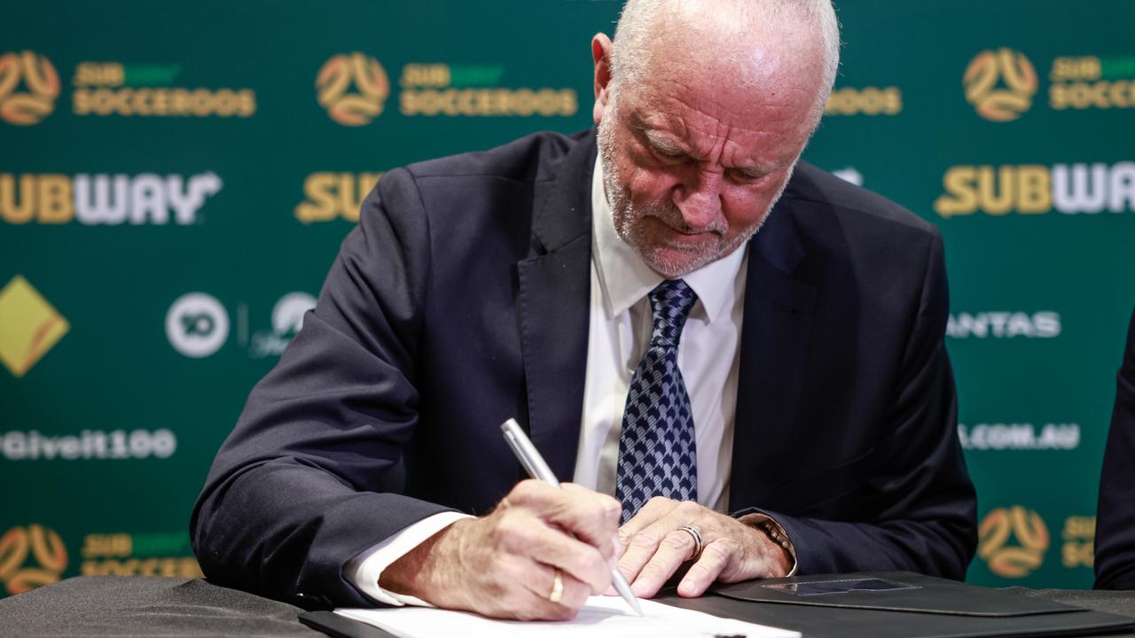 Graham Arnold signs his new contract as Socceroos coach. Picture: Hanna Lassen/Getty Images