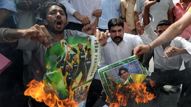 Pakistani cricket fans torch posters of national cricket team players after spot-fixing allegations were revealed by an undercover investigation. Picture: AFP Photo/Aamir Qureshi 