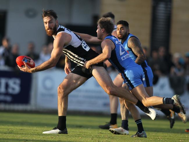 SANFL: Port Adelaide v Sturt at Alberton Oval. 8 June 2019. Port's Charlie Dixon looks to handball under pressure from Sturt's Sam Colquhoun late in the game.(AAP Image/Dean Martin)