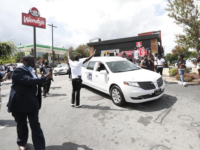 A hearse carrying Rayshard Brooks passes by the area where he was killed near a Wendy's restaurant in Atlanta. A young girl was shot dead near the area over the weekend. Picture: AP