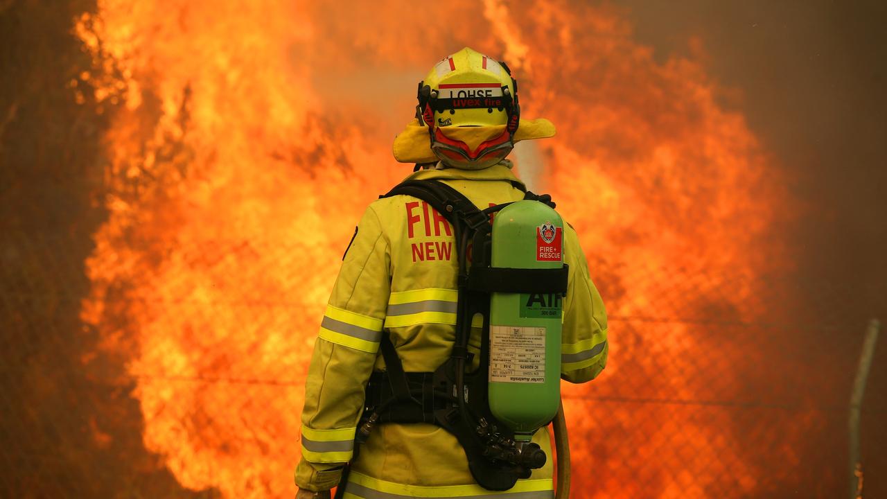 A NSW Fire and Rescue crew member battles a blaze on the Pacific Highway near Taree. Picture: Jane Dempster.