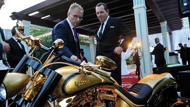 Jeff McGlinn, right, runs an eye over a golden motorbike at an event in Monaco.