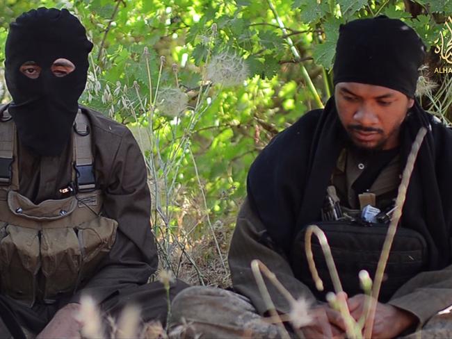 Cambodi_vid: Abu Khaled (aka Neil Prakash) (right), an Australian believed to be from Melbourne, sits alongside fellow Australian Islamic State fighter Abu Nour al Iraq in a propaganda video released by the group in mid-2014. Supplied