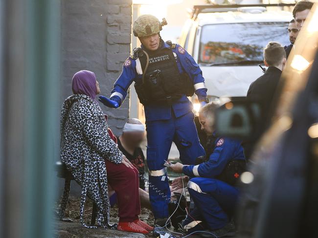 Emergency crews speak to and treat a man and woman outside the house in Surry Hills. Picture: Dylan Robinson